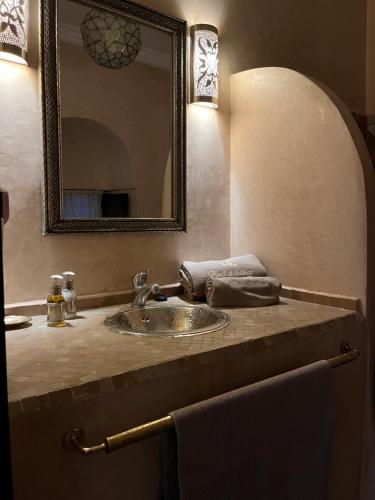 a bathroom with a sink and a mirror at Riad Al Ibtikar in Marrakech