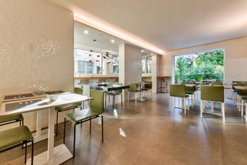 a restaurant with tables and chairs and a large window at Open Hotel in Rimini