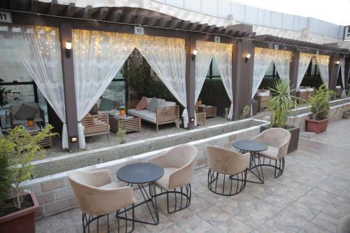 a patio with chairs and tables and a couch at Broad Almkan Apart Hotel in Taif