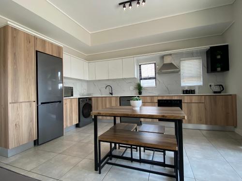 a kitchen with a wooden table and a refrigerator at Penthouse in Waterfall with backup power in Midrand