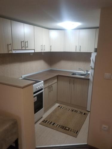 a small kitchen with white cabinets and a sink at Prenociste Lux in Kragujevac