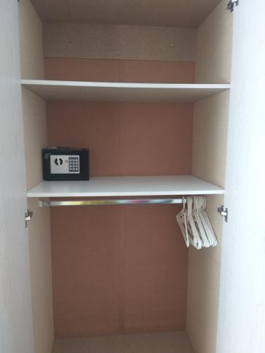 a shelf in a closet with a clock on it at Prince Alfreds in Caledon