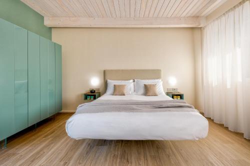 a bedroom with a large bed with white sheets and pillows at Open Hotel in Rimini