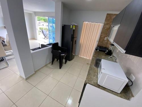 a kitchen with a black chair and a sink at Lindo Apartamento vacacional in Cartagena de Indias