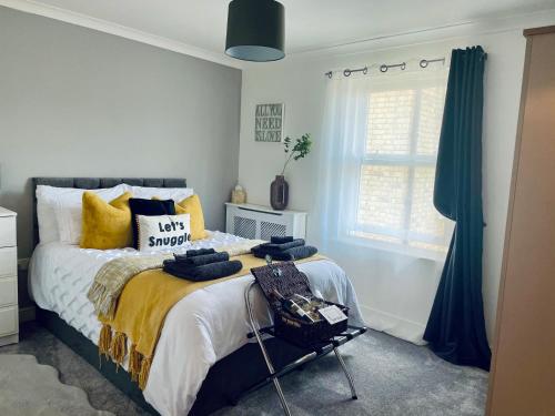 a bedroom with a large bed with yellow pillows at Centrally Located a Home from Home - Free Parking in Kent