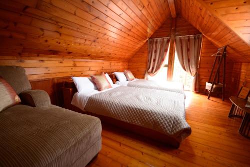 une chambre avec deux lits dans une cabane en rondins dans l'établissement Designer's Hotel Nakadoma Inn - Vacation STAY 32584v, à Maeganeku