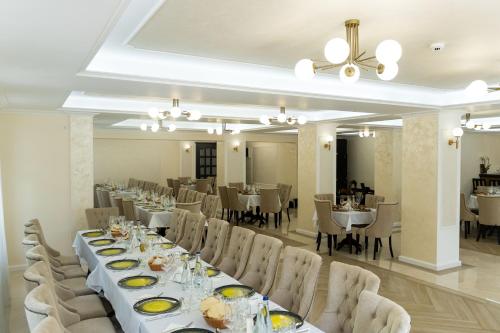 uma sala de jantar com uma mesa longa e cadeiras em Perla Dacilor em Grădiştea de Munte