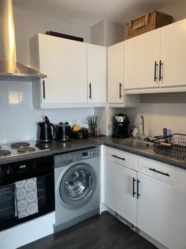 a kitchen with a washing machine and a sink at Centrally Located a Home from Home - Free Parking in Kent