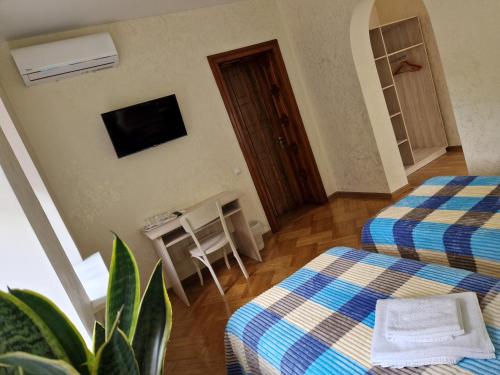 a room with two beds and a television on the wall at Villa ZENKO in Lviv