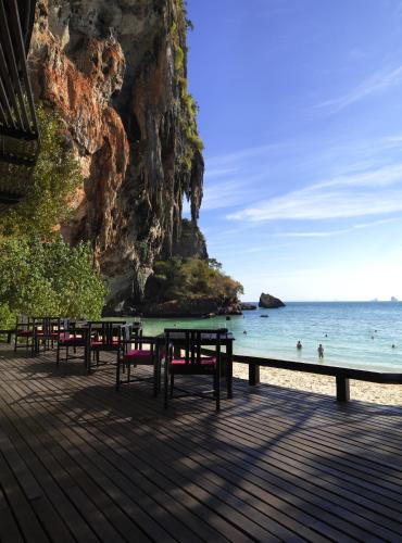 a beach with tables and chairs and the ocean at Rayavadee in Railay Beach