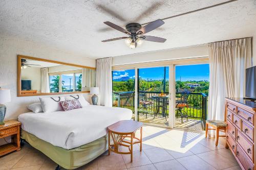 a bedroom with a bed and a balcony at Prince Kuhio 319 in Koloa