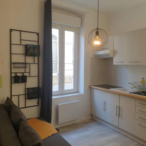 een keuken met een bank en een raam in een kamer bij Studio à deux pas des étangs in Peyriac-de-Mer