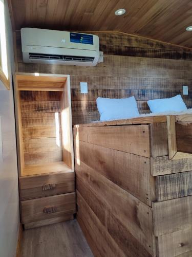 een kleine kamer met een stapelbed en een televisie bij Tiny House Nativa in Montecarlo