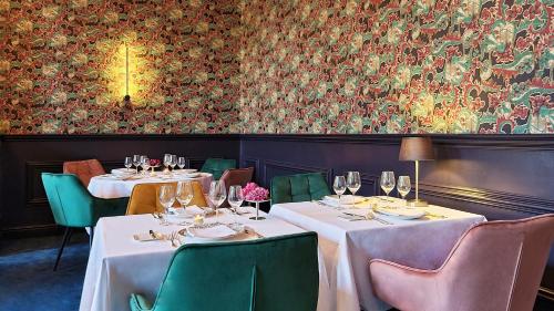 een restaurant met 2 tafels en stoelen met wijnglazen bij Hotel Restaurant Steenhuyse in Oudenaarde