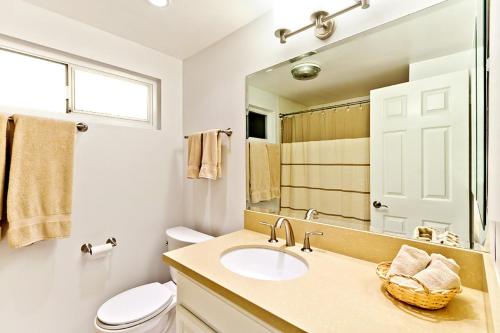 a bathroom with a sink and a toilet and a mirror at Beautiful Views - Sand Section of Manhattan Beach 2 Bed/2 Bath in Manhattan Beach