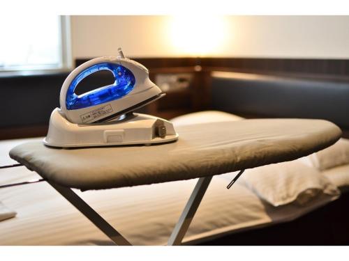 a iron is sitting on top of a bed at Belken Hotel Kanda - Vacation STAY 80890v in Tokyo