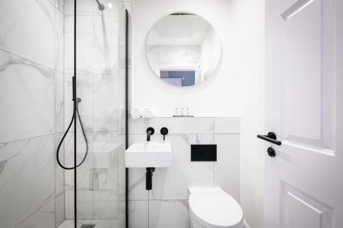 ein weißes Bad mit einem WC und einer Dusche in der Unterkunft Dalton Sq Apartment 1 in Lancaster