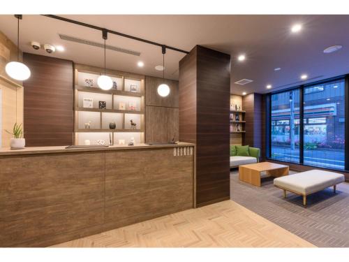 a lobby with a counter and a chair and a couch at Belken Hotel Kanda - Vacation STAY 80916v in Tokyo