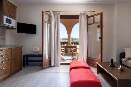 een woonkamer met een rode bank en een balkon bij Vetrinos Apartments in Agios Nikolaos