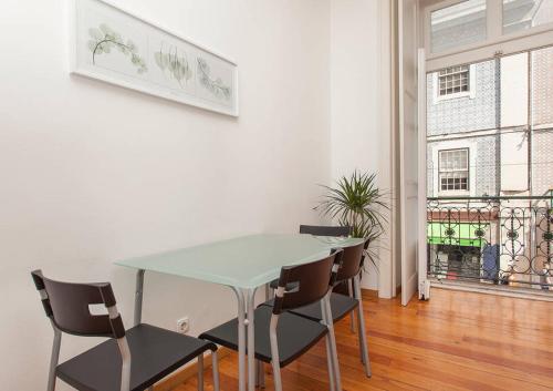 ein Esszimmer mit Tisch und Stühlen und einem Fenster in der Unterkunft Downtown Lisbon in Lissabon