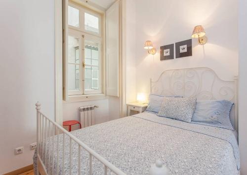 una camera da letto con un letto con cuscini blu e una finestra di Downtown Lisbon a Lisbona