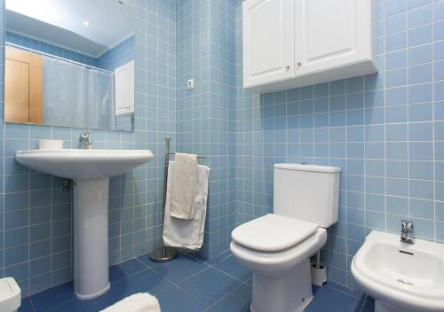 een blauw betegelde badkamer met een toilet en een wastafel bij Downtown Lisbon in Lissabon