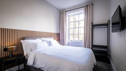 ein Schlafzimmer mit einem weißen Bett und einem Fenster in der Unterkunft Dalton Sq Apartment 1 in Lancaster