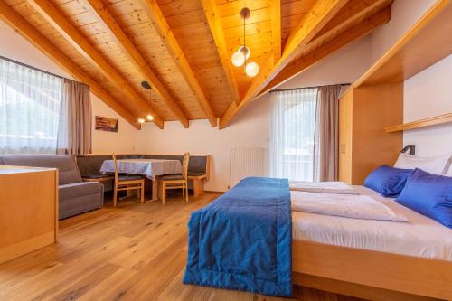een slaapkamer met een bed, een bank en een tafel bij Alpengruss in San Candido