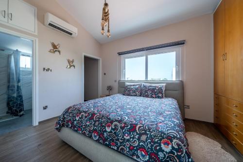 a bedroom with a bed and a window at Dene Hollow Oroklini in Voroklini