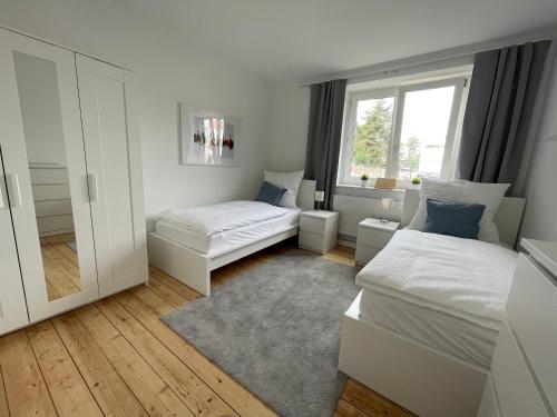 um quarto branco com 2 camas e uma janela em WH Immobilien Design City Appartement Rainshower em Hanôver
