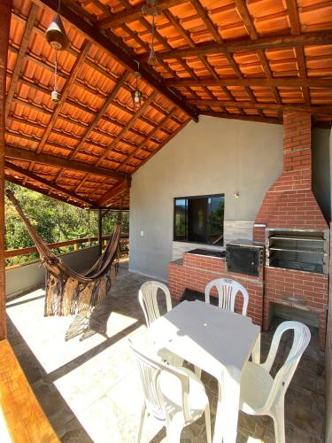 un patio con mesa, sillas y chimenea en Canto das Águas, en Alagoa