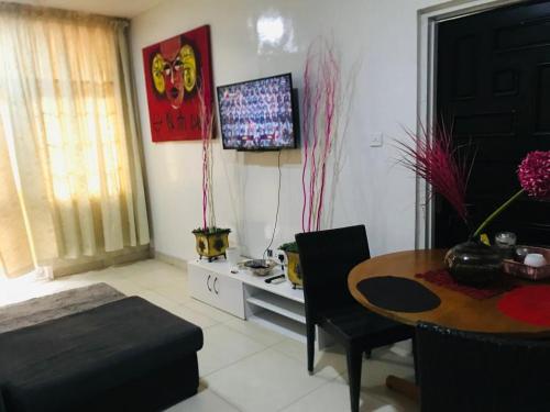 ein Wohnzimmer mit einem Tisch und einem Esszimmer in der Unterkunft Serenity in Accra