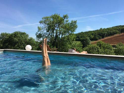 eine Person in einem Schwimmbad mit ihren Füßen im Wasser in der Unterkunft Le Clos des Fayettes in Theizé