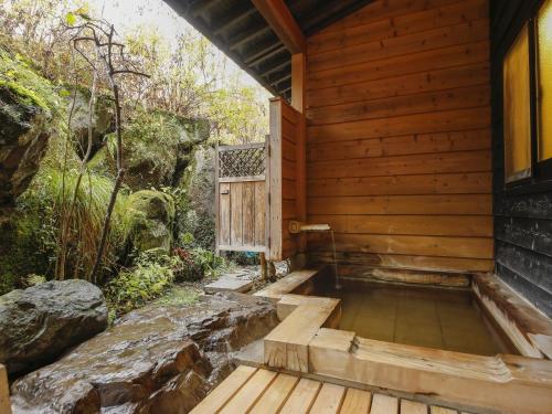 an outside plunge pool in a wooden house with stairs at Ryokan Kutsuroginoya Yuu in Takayama