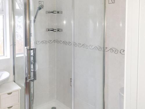 a shower with a glass door in a bathroom at Moor View in Newton Abbot