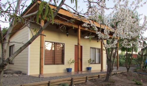 a small yellow house with trees in front of it at Alojamiento Los Nogales in Santa Cruz