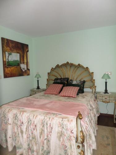 una camera da letto con un grande letto con una coperta rosa di Casal de S.Romão do Meio a Guimarães