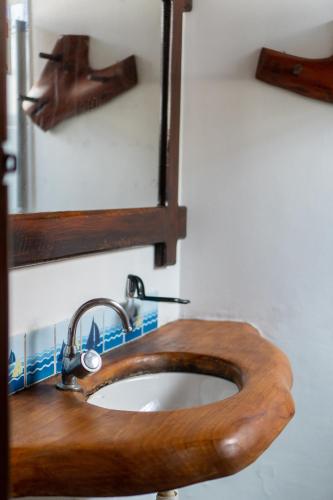 a wooden sink in a bathroom with a mirror at Pousada Capitão Gancho in Barra Grande