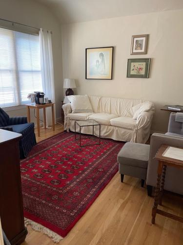 a living room with a white couch and a red rug at SWEET Suite BAKER Street in San Francisco