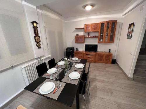 a dining room with a table with plates and wine glasses at CASA MARUJA in Ávila