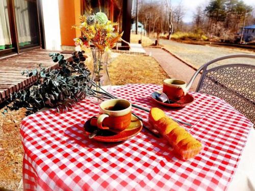 a red and white checkered table with two cups of coffee at Yamanaka Lake ＲＹＯＺＡＮ - Vacation STAY 32157v in Yamanakako