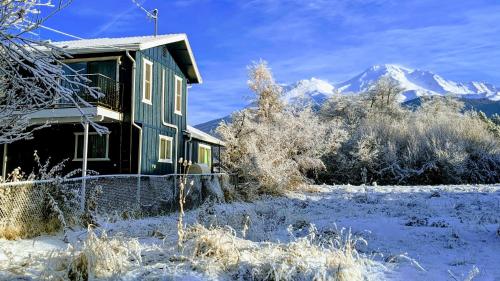a house in the snow with mountains in the background at 4 Elements House:Central, Views-Every Rm, AC, Pets in Mount Shasta