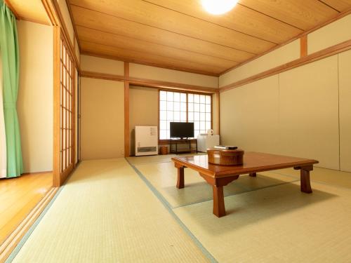 a living room with a table and a tv at Yamanaka Lake ＲＹＯＺＡＮ - Vacation STAY 32157v in Yamanakako