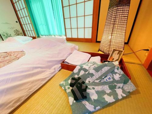a bedroom with a bed and a laptop on the floor at Yamanaka Lake ＲＹＯＺＡＮ - Vacation STAY 32157v in Yamanakako