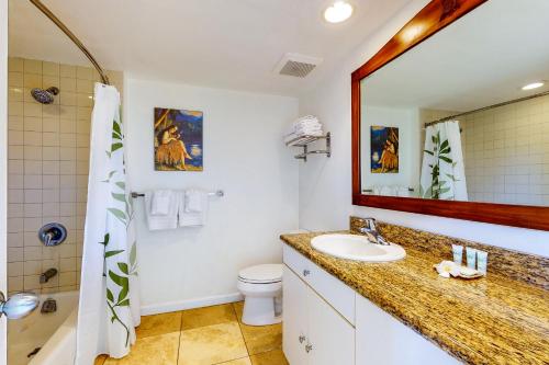 a bathroom with a sink and a mirror and a toilet at Islander on the Beach 250 in Kapaa