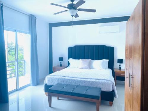 a blue bedroom with a bed and a ceiling fan at Gaia Residence Deluxe in San Felipe de Puerto Plata