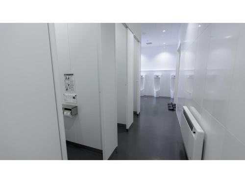 a bathroom with a row of urinals and a hallway at The Lodge Moiwa 834 - Vacation STAY 36148v in Niseko