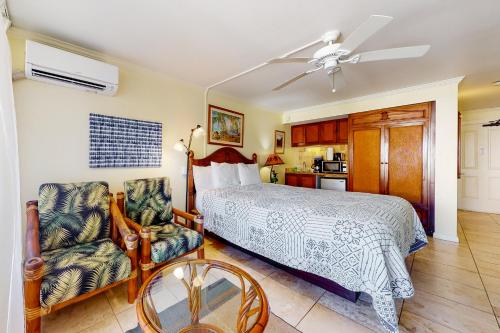 a bedroom with a bed and a table and a chair at Islander on the Beach 361 in Kapaa