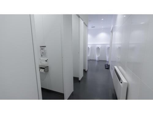 a bathroom with a row of urinals and a hallway at The Lodge Moiwa 834 - Vacation STAY 36156v in Niseko