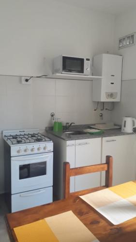 a kitchen with white appliances and a table with a table at Lo de Nora, ColónER in Colón